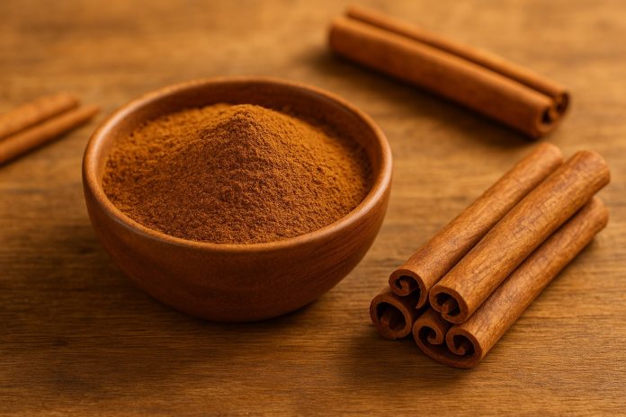 Scorțișoară pudră și batoane de scorțișoară pe fundal rustic, lângă un bol cu mirodenii