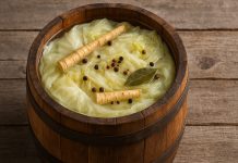 Trucul tradițional care menține zeama de varză limpede până la primăvară. Puțini îl mai știu Butoi cu varză murată și saramură limpede, alături de hrean și ingrediente tradiționale folosite la murare.