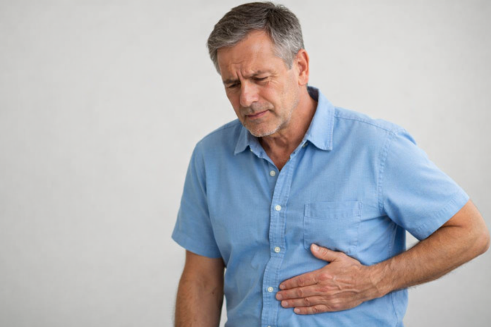 Persoană adultă ținându-se de partea dreaptă a abdomenului din cauza durerii