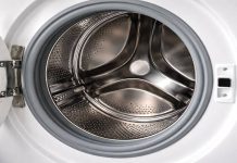 Cum să cureți mașina de spălat cu oțet: metoda simplă care elimină mirosul și murdăria ascunsă Mâini turnând oțet în sertarul unei mașini de spălat pentru curățare eficientă