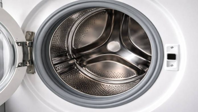 curatare-masina-spalat-otet.jpg Mâini turnând oțet în sertarul unei mașini de spălat pentru curățare eficientă