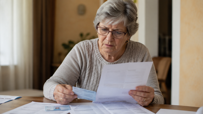 Femeie verificând documente pentru pensionare anticipată