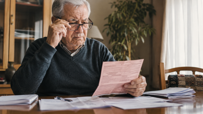 ce-se-intampla-cu-pensiile-pana-la-finalul-anului.jpg Pensionar analizând documente și talon de pensie în contextul verificării dosarului de pensie.