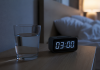 Te trezești cu gura uscată noaptea? 7 cauze frecvente pe care nu ar trebui să le ignori Femeie trezită noaptea care bea apă din cauza senzației de gură uscată