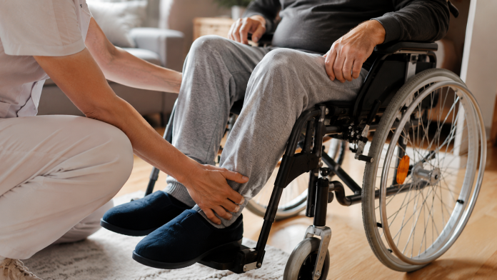 Persoană îngrijind un adult cu dizabilitate într-un cadru domestic, concept de indemnizație de însoțitor.