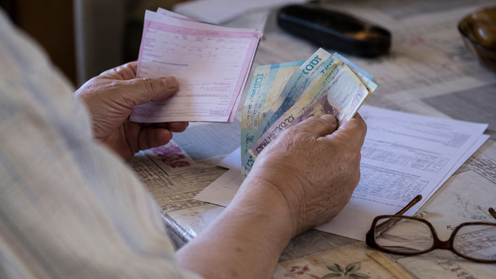 punctul-de-pensie-majorare.jpg Pensionar analizând documente privind pensia și veniturile