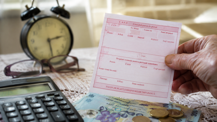 pensionarii-care-pot-primi-bani-in-plus.jpg Pensionar ținând în mână talonul de pensie și bancnote românești, ilustrând posibilitatea acordării unui sprijin financiar suplimentar.