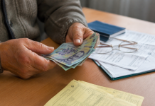 Pensionar numărând bani și documente privind ajutoarele financiare