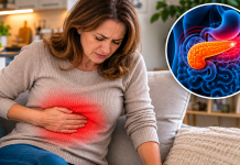 Persoană ținând mâna în partea superioară a abdomenului, sugerând disconfort pancreatic.