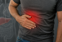 Adult cu mâna în partea dreaptă a abdomenului, sugerând disconfort la nivelul ficatului.
