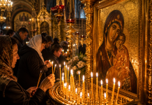 Credincioși rugându-se în fața Icoanei Maicii Domnului Prodromița la o biserică ortodoxă
