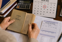 Persoană analizând documente de pensie și un carnet de muncă înainte de depunerea dosarului pentru pensionare anticipată.