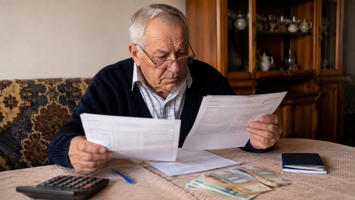 pensionari-indemnizatie-insotitor.jpg Pensionar care verifică documentele pentru pensie și indemnizația pentru însoțitor.