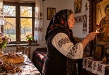 Femeie care aprinde candela de Sfântul Dumitru, potrivit obiceiurilor păstrate în familie