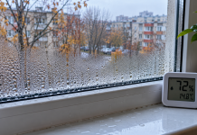 Condens pe geamuri în fiecare dimineață? Greșeala care aduce umezeală în casă și ce trebuie să faci ca să scapi de problemă Geam de apartament acoperit cu picături de condens într-o dimineață rece de toamnă, cu apă acumulată pe pervaz și un higrometru care indică umiditate ridicată.